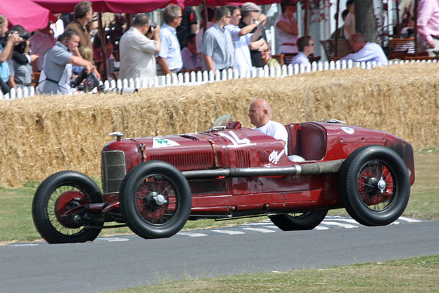 Photo d'une Alfa Romeo P2 rouge en pleine démonstration avec un conducteur au volant