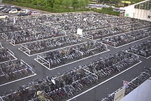 Hundreds of bicycles, grouped in rectangular parking places with driving paths in between.