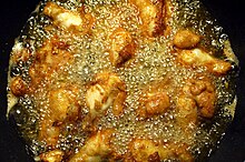 Куриные крылышки обжариваются на сковороде с кукурузным маслом