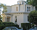 Una disposición similar de planta baja de mampostería y segundo piso con estructura de madera, pero construida en un estilo decorativo típico de San Francisco. Casa octágono Feusier, San Francisco, California (construido en 1857).