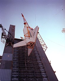 A crane hoists the Facilities Test Article, a mockup of an actual shuttle orbiter, into the Saturn V Dynamic Test Stand at MSFC to test the procedures in preparation for the dynamic test of Space Shuttle Enterprise. Space Shuttle Pathfinder OV-098 original configuration.jpg