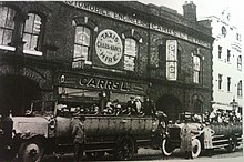 Charabancs picking up passengers in Bury, Lancashire for a wakes week excursion around 1920 Wakes week charabancs.jpg