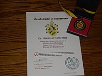 Выпускаемые герцогством сертификат дворянства и медаль