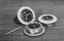 Three Enigma rotors and the shaft, on which they are placed when in use. Enigma-rotors.jpg