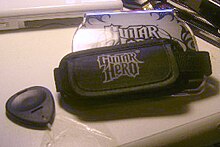 O "Guitar Grip", uma unidade do tamanho de uma mão que cabe no Nintendo DS com quatro botões coloridos em uma extremidade e uma alça ajustável que o jogador usa para segurar o Grip e o DS no lugar enquanto joga. O Grip apresenta o logotipo "Guitar Hero: On Tour" de um lado.