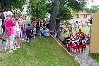 Průvod svatebčanů jde přes ves za Pazderníkem