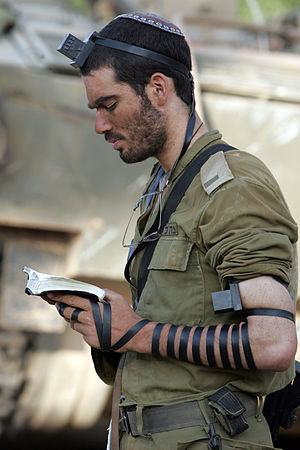 English: An IDF soldier prays with tefillin in...