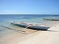 Jukung atau banca dengan "sayap" di pantai Manamoc, Filipina