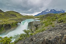 Une grande cascade verte dans une plaine verte.