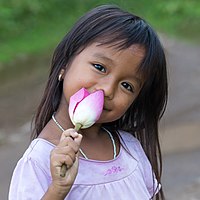 Smiling girl holding a lotus flower