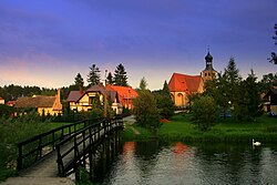 View of Swornegacie with the Brda River in the foreground and the Saint Barbara church in the background