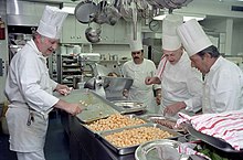 Under the direction of White House Executive Chef Henry Haller, chefs prepare food for a state dinner honoring Australian Prime Minister Malcolm Fraser in 1981. White House chefs 1981.jpg