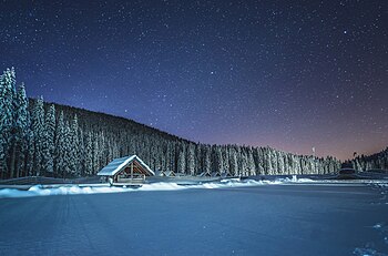 Winter cottage at night at Pokljuka