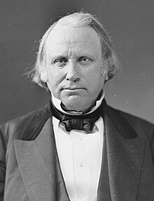 A head-and-shoulders, black-and-white photograph of a middle-aged man in formal attire. His hair appears to be grey. His expression is sober and dignified.