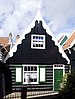 Houten huis met afluiving links opzij en een topgevel met uitgeschulpte windveren