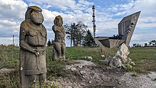 Polovtsian stone sculptures of 9-13 centuries on Mount Kremenets in Izium after the battle. The statue in the right was completely destroyed; nearby monument to WWII heroes (in the background) is partially destroyed. Polovtsian babas on Mount Kremenets after Russian shelling (02).jpg