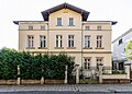 Wohnhaus in offener Bebauung, mit Einfriedung, Vorgarten und Garten