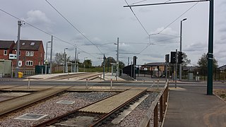 The same view in 2016, with Wilford Lane crossing, secure compound and siding