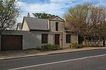 A rectangular, 2-rooms deep house with an iron roof. The end-gables are clipped, but there is a square and pedimented front gable dating from c1850. The facade woodwork is modern. These properties form an integral part of the historical and architectural nucleus of Paarl. The houses on these erven, the majority of which date from the nineteenth century are representative of the Cape Dutch, Georgian. Victorian and Edwardian styles