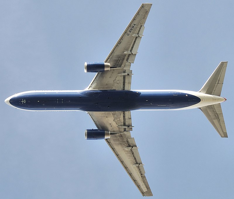 Underside view of a jet in-flight. Each wing of the two wings have an engine. Towards the left are the horizontal stabilizers.