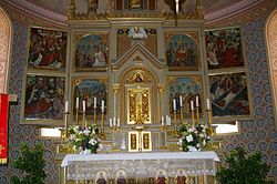 Altar candles, along with chancel flowers, sit atop of the altar of St. Arsacius's church in Ilmmunster, Bavaria. Ilmmuenster Kirche Altar.jpg