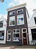 Winkel/woonhuis met bakstenen lijstgevel, kroonlijst en zadeldak (Gouda-Centrum)