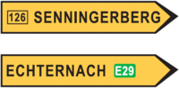 Uewen: Richtung fir op de Sennengerbierg; d'Schëld steet um CR126. Ënnen: Richtung fir op Iechternach; d'Schëld weist un, datt een eréischt méi spéit op d'Europastrooss E29 kënnt.