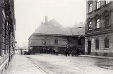 Photographie en noir et blanc d'une rue avec plusieurs personnes à l'arrière-plan