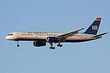 Side view of airliner in flight, with extended landing gear.