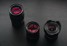Anti-reflective coatings are often used in camera lenses, giving lens elements distinctive colors. Such colors indicate the wavelength of visible light least affected by the antireflective properties of the coating. A variety of colors can be produced whose precise hue depends entirely on the thickness of the coating. Color or cast can change radically when the coating is increased or decreased in thickness by tens of nanometers. Voigtlander lenses 75mm, 50mm, and 15mm.jpg