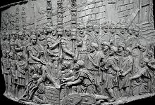 bas-relief rectangulaire convexe, montrant un homme sur un autre ; un autre s'agenouille devant lui ; autour d'eux, de nombreux soldats et prisonniers.