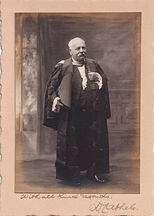 A card with a photograph of David Cathels, a mostly bald man with a white moustache wearing a robe. At the bottom of the card is a hand-written note, "With all best regards D Cathels."