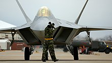F-22A from the 1st Fighter Wing, 27th Fighter Squadron, Langley AFB, Virginia being marshalled into place on the flightline F-22-acc.jpg