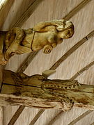 Deux sculptures bois. Sirène tenant un peigne d'une main et un miroir de l'autre. Juste à côté, tête de monstre avalant une poutre.