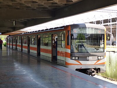Двухвагонный состав из вагонов 81-717М с прямыми кабинами в оранжевой окраске на станции «Давид Сасунский»