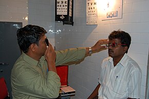 A doctor uses a trial frame and trial lenses to measure the person's refractive error. Refrarction error test.JPG