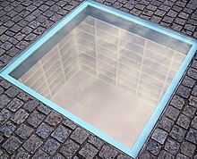 A memorial on Bebelplatz, site of a Nazi book burning in May 1933. Empty shelves are visible through a window in the pavement. Bebelplatz Night of Shame Monument.jpg