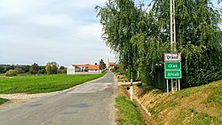 Három nyelvű helységnévtábla az út mellett, Olasz község déli határánál