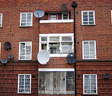 Satellite dishes on a wall in Hackney, London. The small oval dishes are most likely being used for viewing British services, and are known as Minidishes. The larger dishes are most likely being used for viewing satellite services from outside the UK. Satellite dishes in the UK.jpg