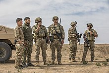 U.S. JTAC personnel demonstrate AH-64 Apache live-fire capabilities with Syrian Democratic Forces personnel (left), 20 March 2021 U.S. Army and Air Force Partners with SDF to Conduct AH-64 Live-Fire March 2021.jpg