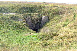 Rocky opening to the cave on a grassland