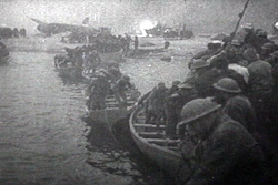 Brit katonák mentőcsónakokból készített ideiglenes hídon érik el a várakozó hajókat. Háttérben egy Bristol Blenheim, vagy egy Lockheed Hudson