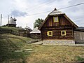 Holzhaus mit Kirche im Hintergrund