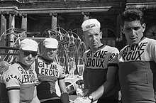 A black and white photograph of four cyclists wearing jerseys with Gitane–Leroux insignia.