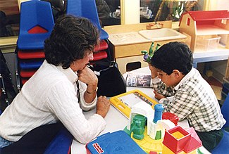 A special education teacher assists one of her students Special ed teacher.jpg