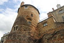 Vue d'une tour avec sur la droite vestiges d'un bâtiment ancien.
