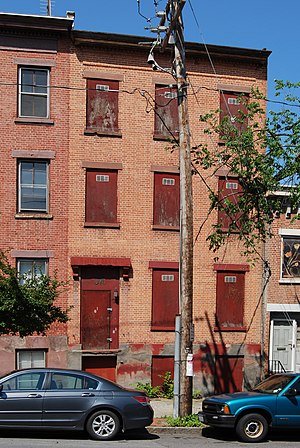 Urban blight (rowhouse with boarded windows an...