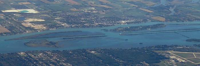 A 2016 aerial photo of the Detroit River, facing east. The town of Amherstburg is at top; Grosse Ile is at the bottom. Above the Livingstone Channel are Crystal Island (left) and Bois Blanc Island (right). To the bottom are Stony Island, Powder House Island, Fox Island, and Sugar Island, from left to right.