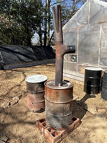 Biochar (charcoal) is produced in this double burn barrel. Chunks of woody biomass are placed within an inner barrel, feedstock to "cook" the inner biomass is placed around the inner barrel, and then the feedstock is ignited. This converts the woody biomass into almost pure carbon. The carbon biochar is then used to amend compost. This sequesters carbon, and provides a good home more microbes in the soil. Some advanced biochar units can capture the heat for heating homes, water, air, and even produce electricity with the aid of a stirling engine.