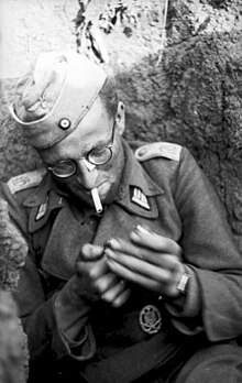 A Wehrmacht soldier smokes in a trench in Romania, 1944. Bundesarchiv Bild 101I-712-0491-26, Leutnant der Division "Grossdeutschland", rauchend.jpg